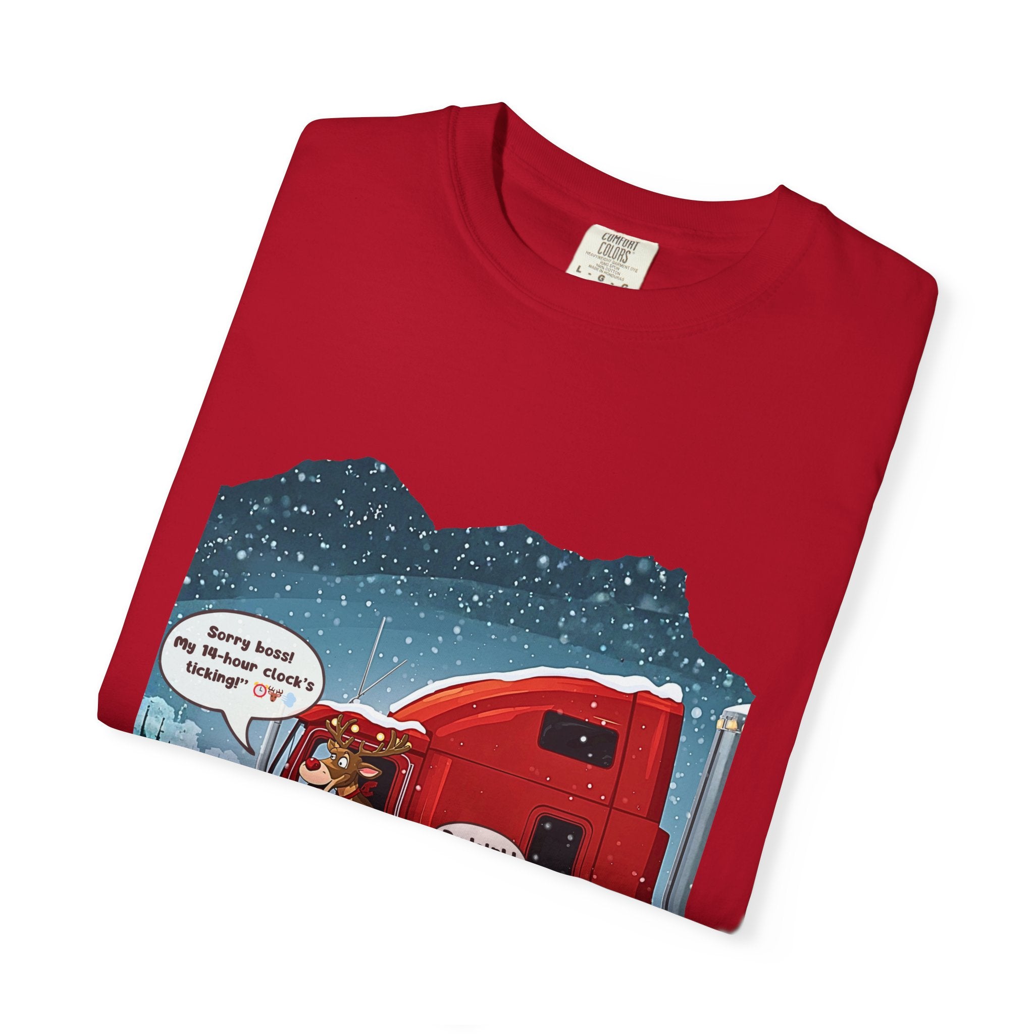 Red garment-dyed T-shirt featuring a Christmas trucking scene with a red truck in snowfall and a speech bubble joke.